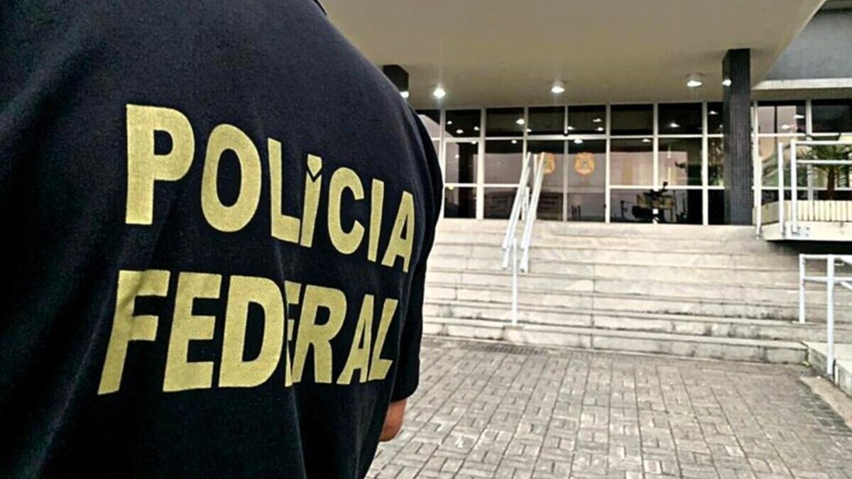 Imagem colorida mostra parte do colete de um agente da Polícia Federal