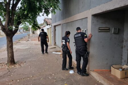 Imagem mostra policiais na porta de uma casa