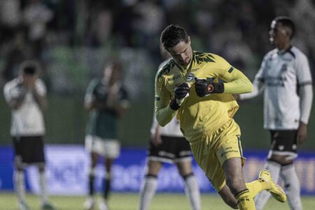 Goleiro Tadeu comemorando com o escudo do Goiás