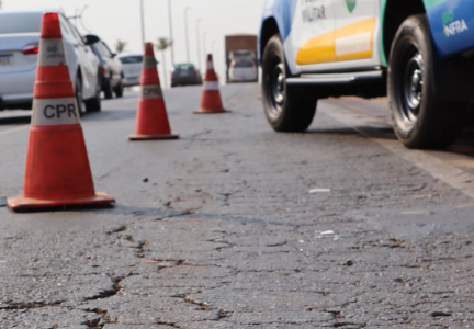 Imagem mostra uma rodovia e uma viatura parada