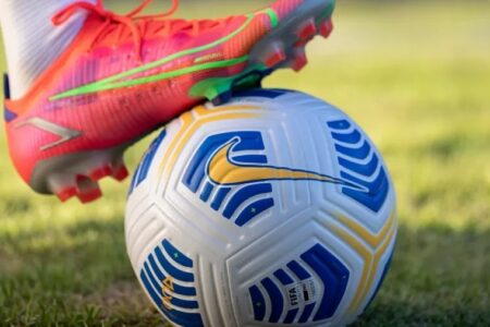 jogador pisando na bola em campo de futebol