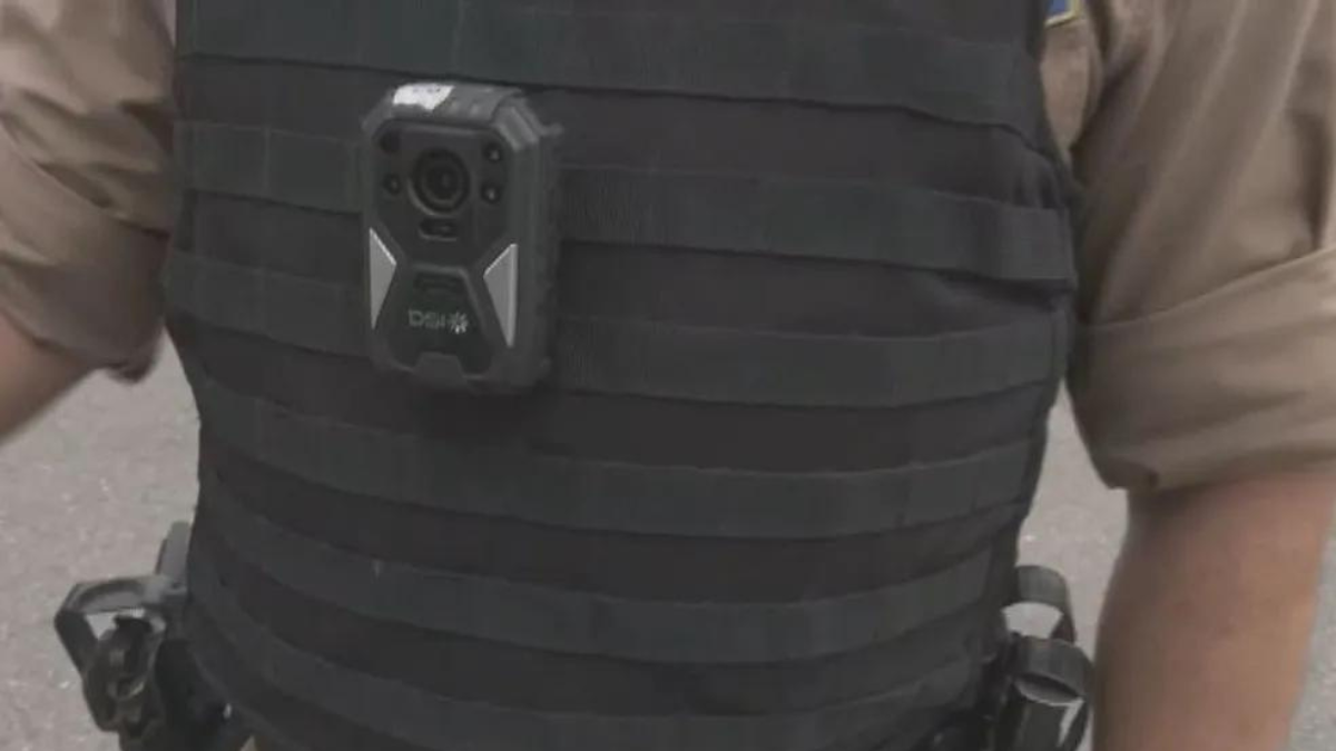 Imagem colorida mostra uma câmera instalada na farda de um policial.