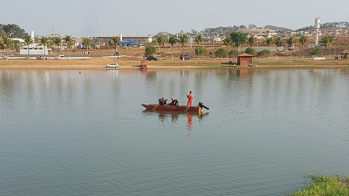 Imagem colorida mostra um barco do Corpo de Bombeiros parado no meio de um rio durante o trabalho de buscas.