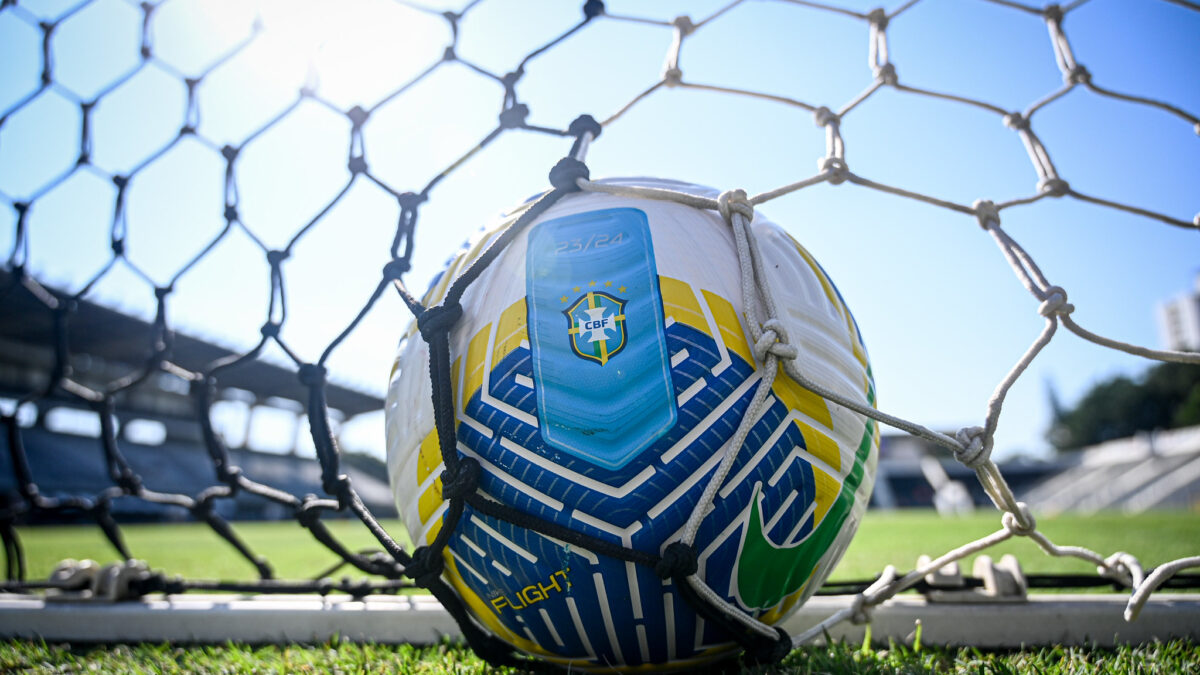 Bola no fundo da rede de um campo de futebol