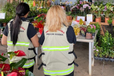 Imagem colorida mostra duas fiscais do Procon em uma loja de flores.