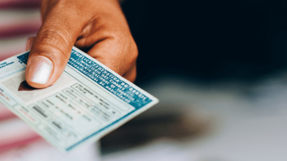 Imagem colorida mostra uma Carteira Nacional de Habilitação (CNH) na mão de uma pessoa.