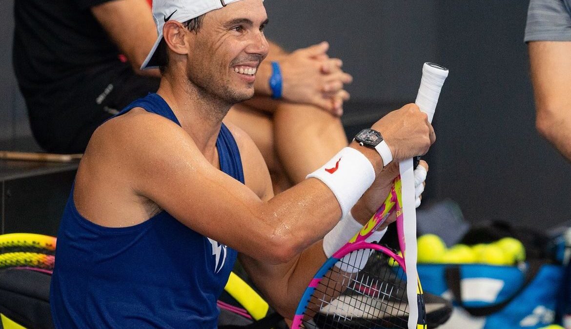 Rafael Nadal sorrindo com uma raquete na mão