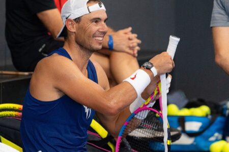 Rafael Nadal sorrindo com uma raquete na mão