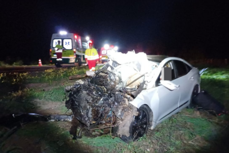 Imagem colorida mostra um carro branco completamente destruído após um grave acidente na BR-153.