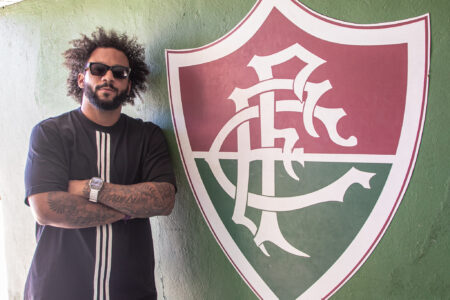 Marcelo ao lado do escudo do Fluminense em Xerém