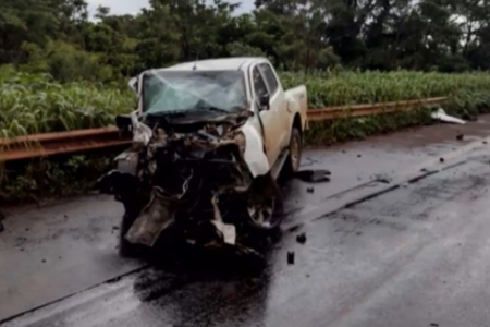 Imagem colorida mostra uma caminhonete branca com a frente destruída após um acidente.