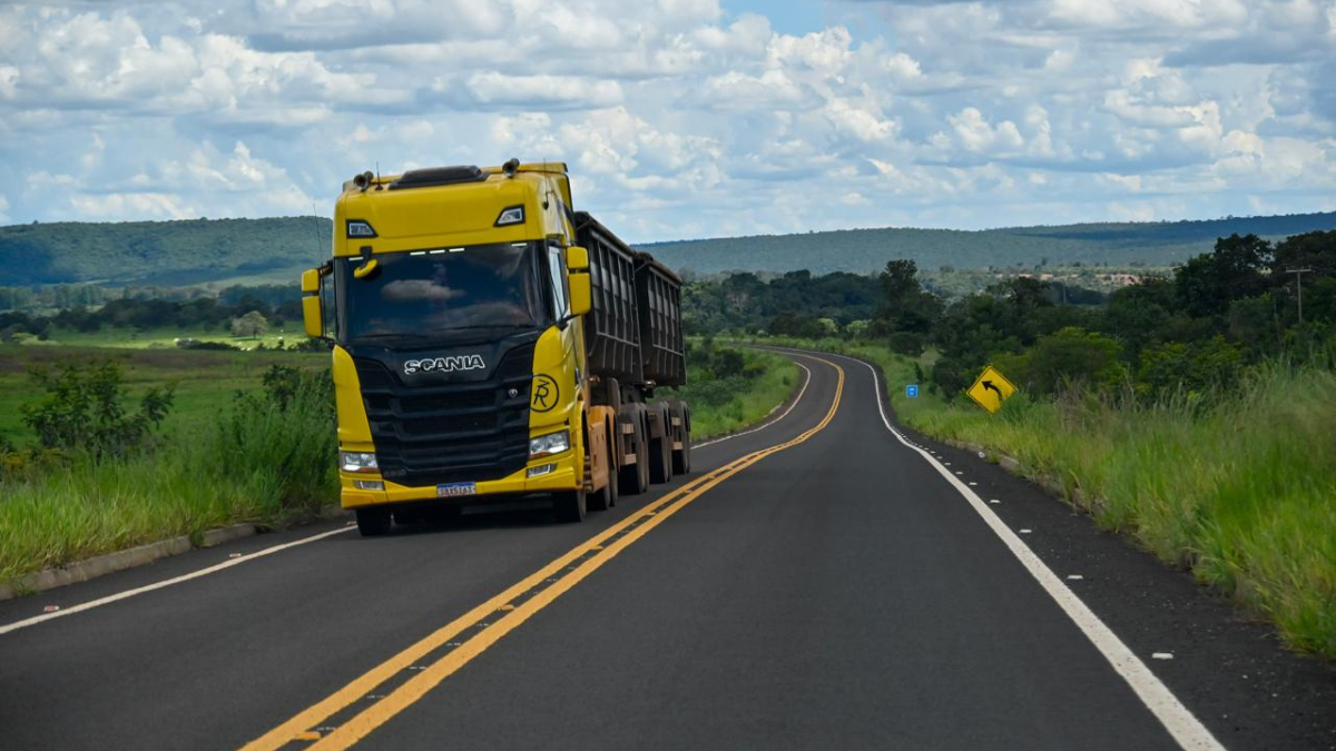 Imagem colorida mostra um caminhão em uma estrada.