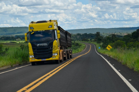 Imagem colorida mostra um caminhão em uma estrada.