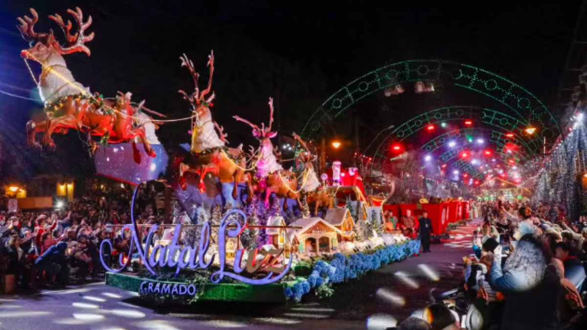 Imagem do grande desfile de natal em Gramado, com renas no trenó e luzes coloridas