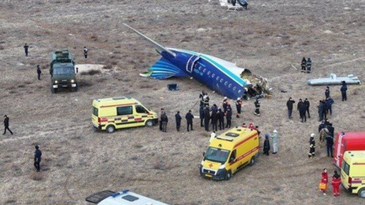 Imagem da calda do avião repartida e agentes no local