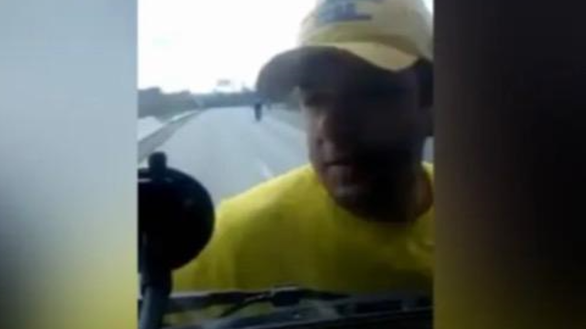 Manifestante pendurado no para-brisa de caminhão (Foto: Reprodução)