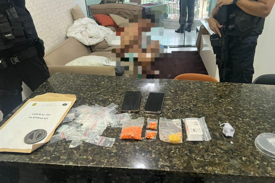 A imagem mostra um homem sendo preso suspeito de integrar um grupo criminoso