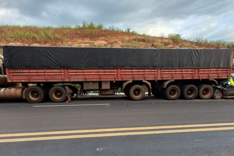 Imagem colorida mostra uma carreta parada em uma rodovia e uma caminhonete que bateu na traseira.
