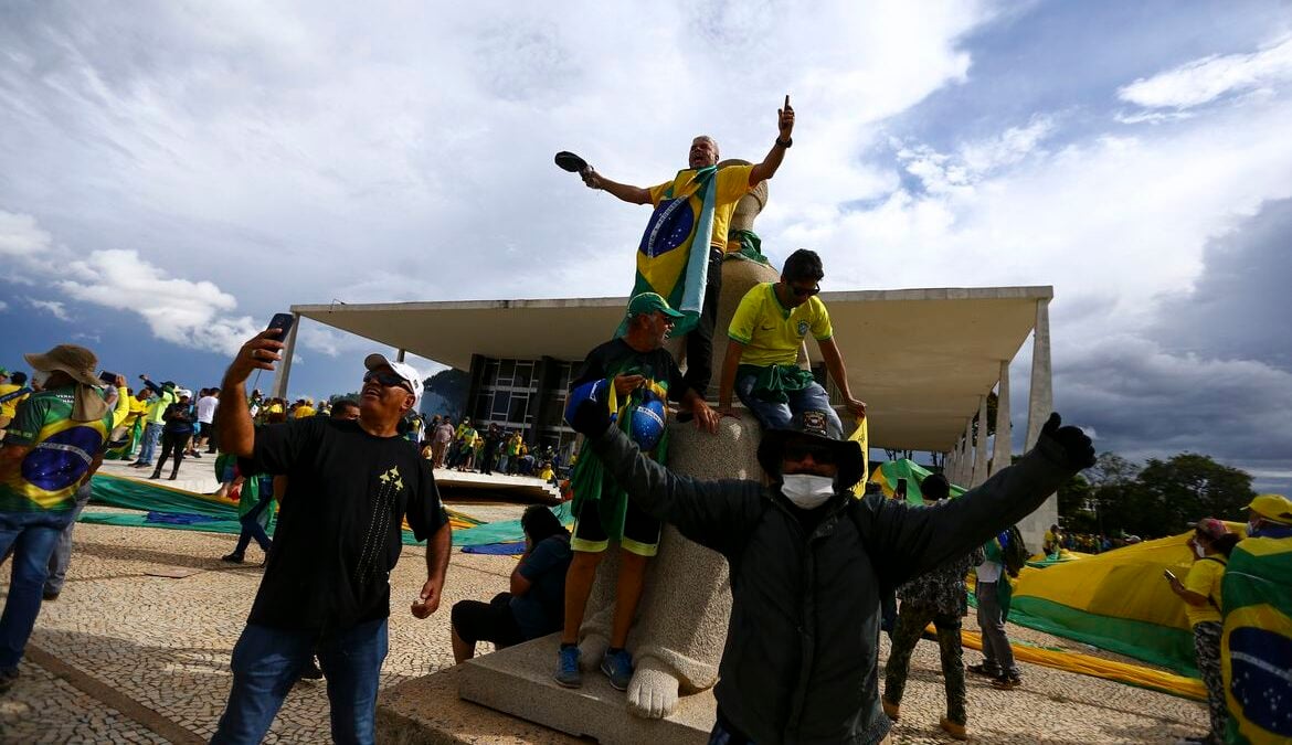 Bolsonaristas sobre estátua da deusa grega Têmis, na frente do STF, durante atos golpistas de 8 de janeiro (Foto: Agência Brasil)