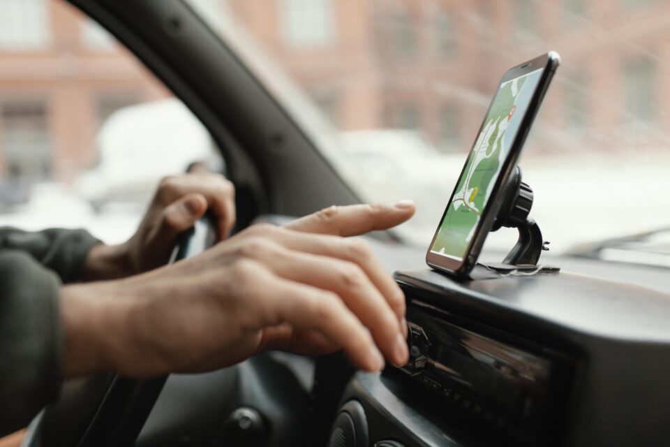 A imagem mostra um motorista de aplicativo acessando um GPS para inciar viagem