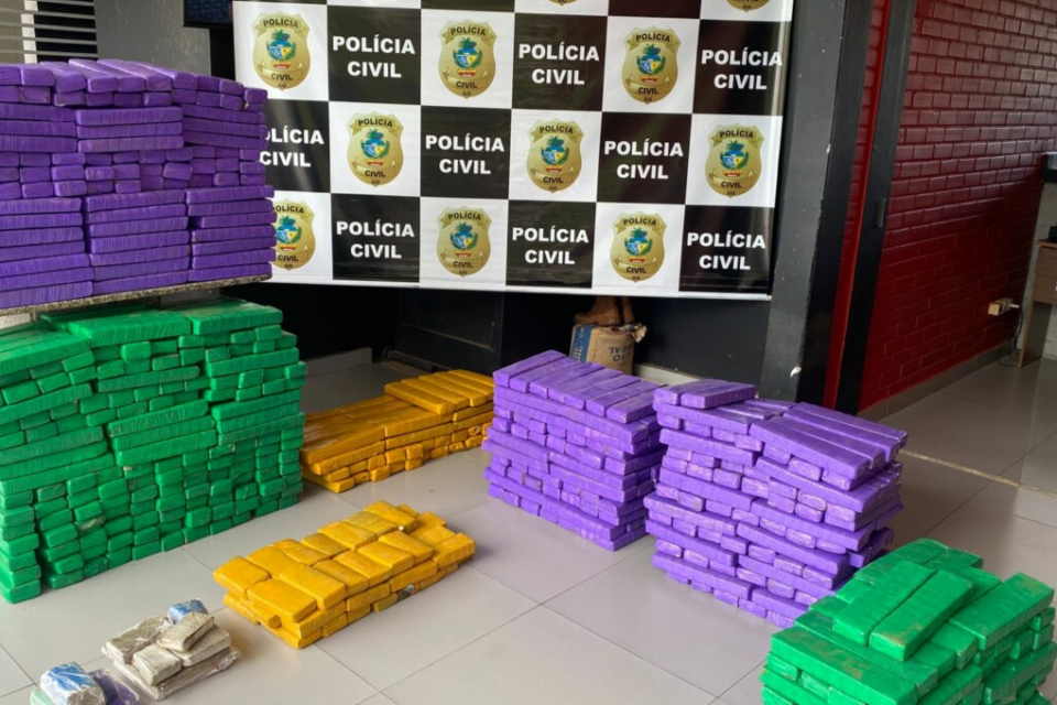 Imagem colorida mostra diversos pacotes com drogas em cima de uma mesa branca.