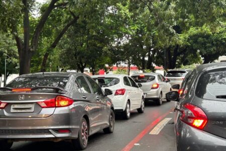 Imagem colorida mostra uma fila de carros parada em uma rua de Goiânia.