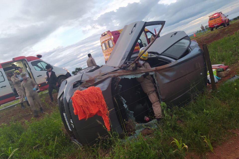 A imagem mostra um veículo tombado após acidente. Equipes de resgate do Corpo de Bombeiros estão realizando o resgate das vítimas