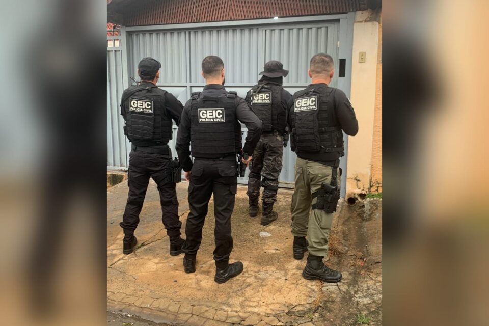 A imagem mostra uma equipe de policiais civis na porta de um dos investigados