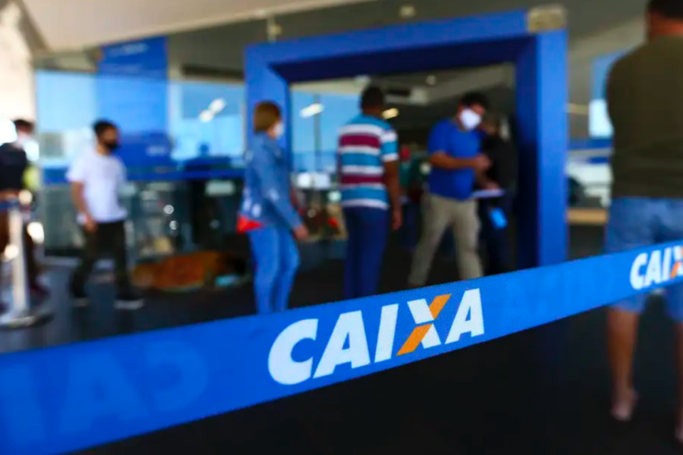 Pessoas em uma fila para entrar no banco da Caixa Econômica