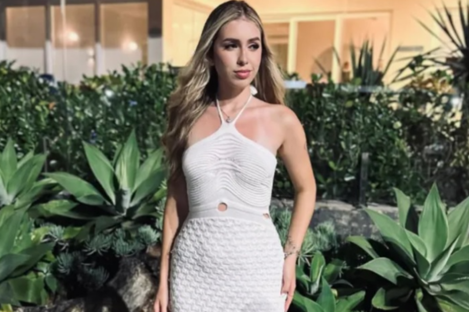 Imagem da ex-miss usando um vestido branco