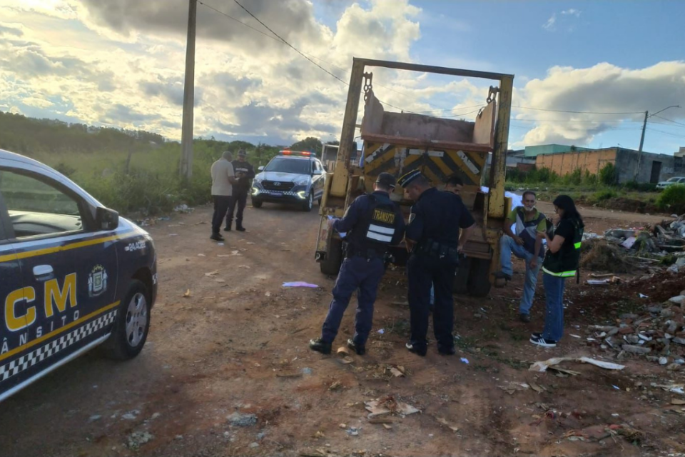 Imagem colorida mostra, do lado direito, um caminhão de entulho com agentes da GCM atrás dele e do lado esquerdo, uma viatura da Guarda realizando uma fiscalização