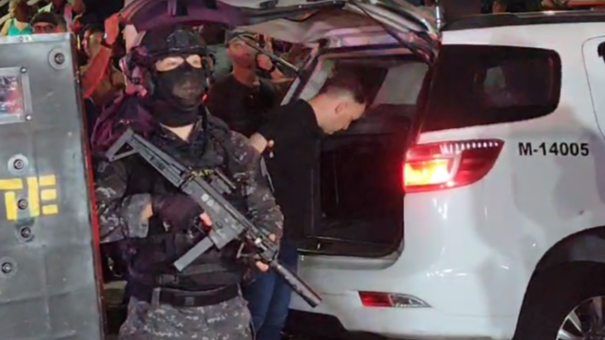 Autor dos disparos sendo levado por policiais