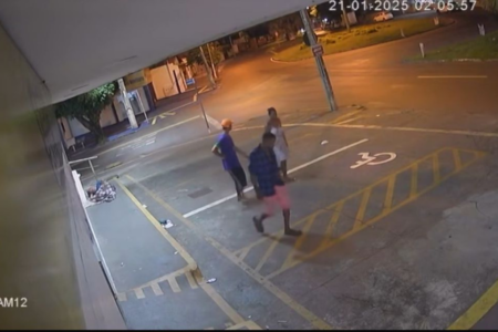 Imagem colorida decâmreas de segurança mostram três pessoas andando em uma calçada.