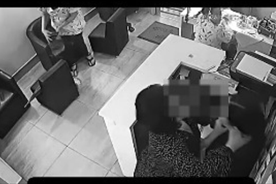 A imagem mostra uma mulher agredindo uma recepcionista de uma esmaltaria