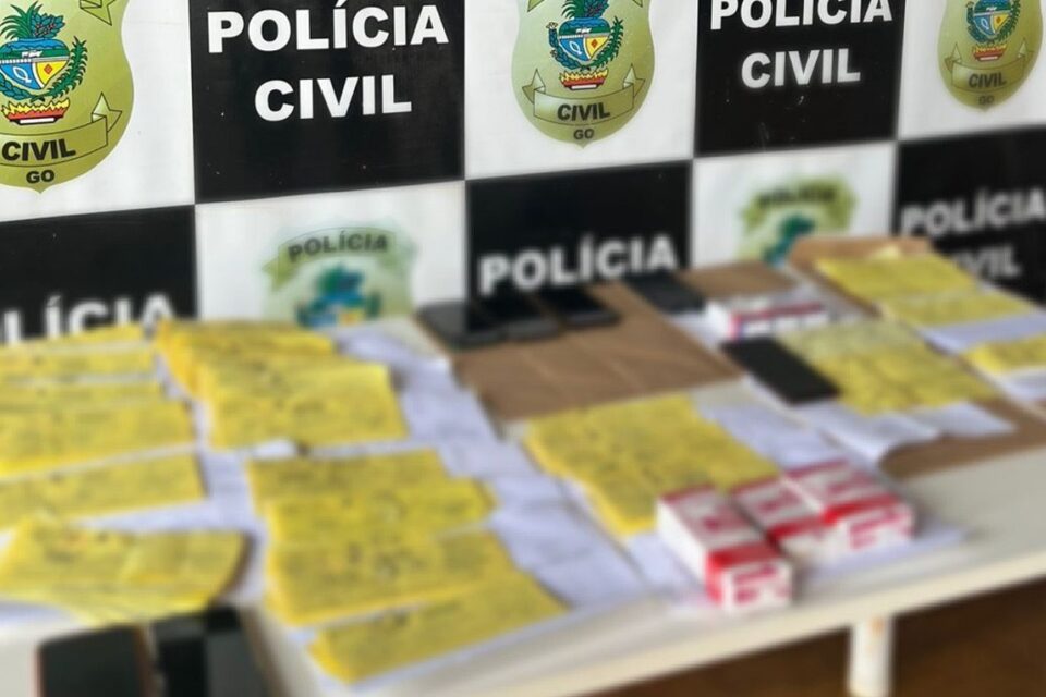A imagem mostra uma mesa da Polícia Civil e sobre ela diversos medicamentos apreendidos e diversas receitas de uso controlado adulteradas para venda ilegal