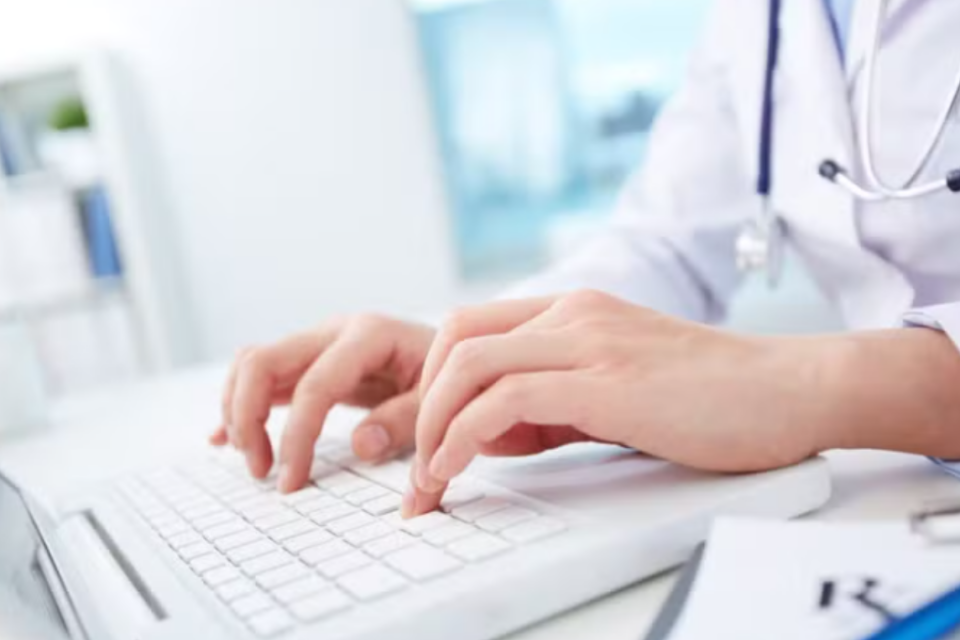 Imagem de um médico mexendo no computador
