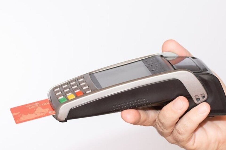 A imagem mostra uma máquina que recebe pagamentos com inserção de cartões