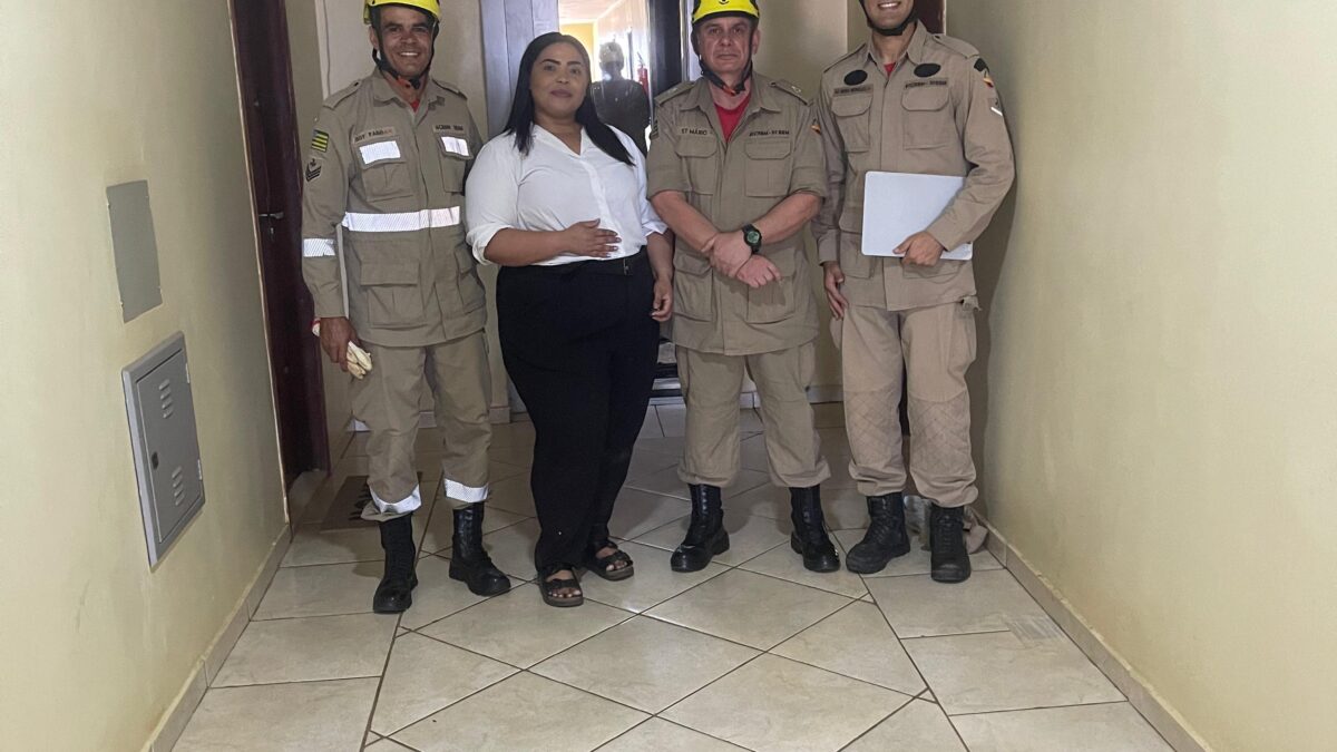 A imagem mostra a vítima juntamente com a equipe de resgate do Corpo de Bombeiros que a tirou do elevador