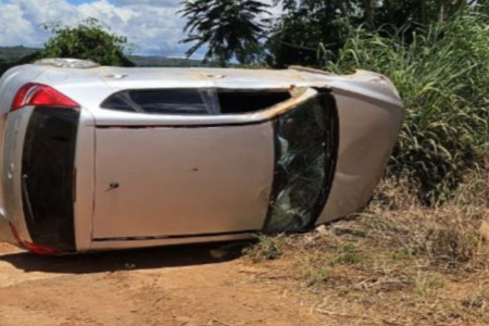 Imagem colorida mostra um carro prata capotado