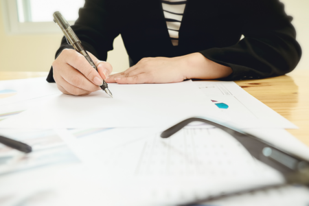 Imagem de uma pessoa usando caneta para escrever em um papel