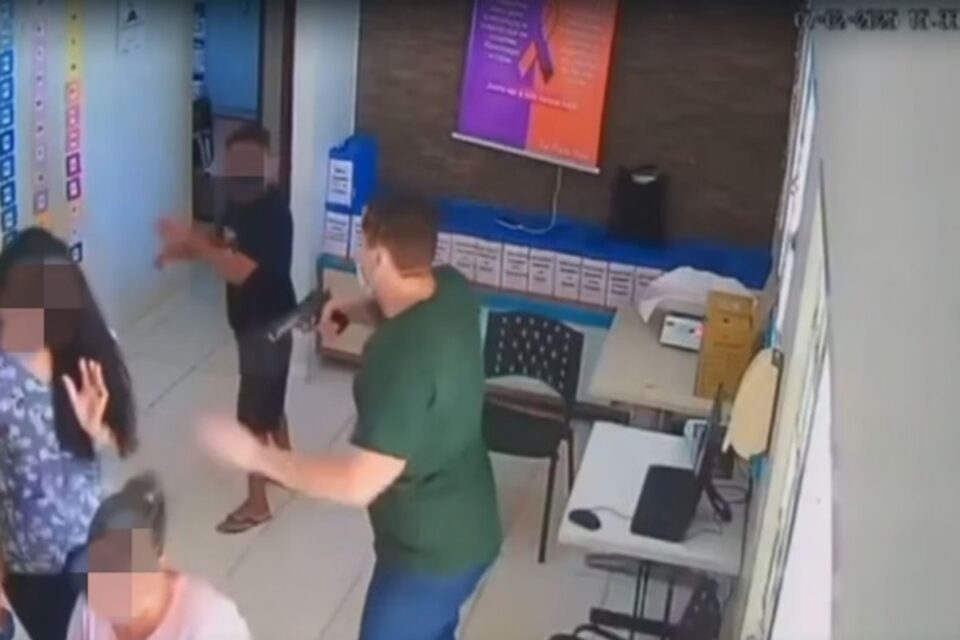 A imagem mostra um homem armado mandando as vítimas para uma sala anexa na UBS
