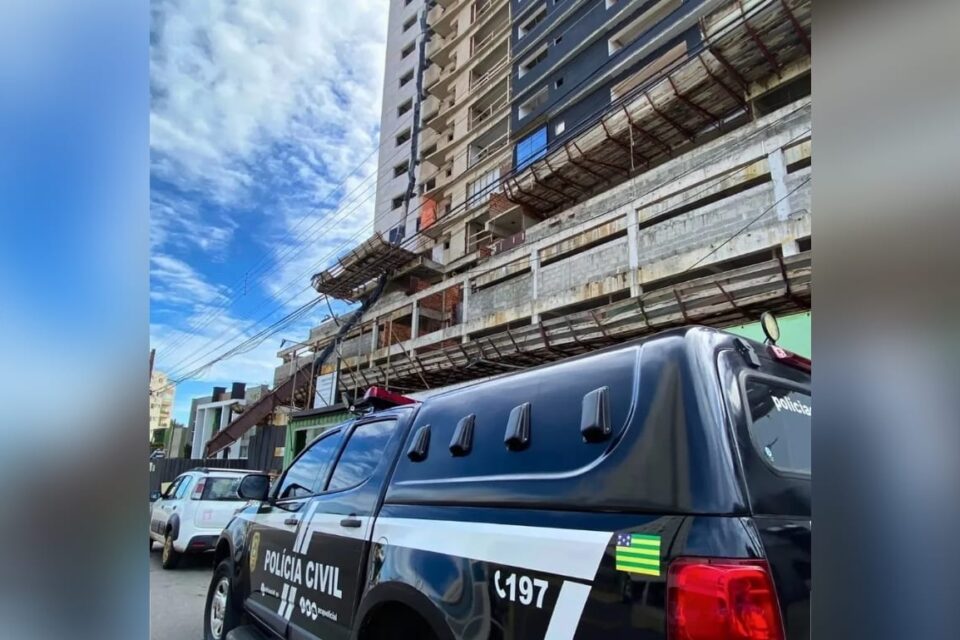 A Imagem mostra uma viatura da Polícia Civil em frente ao prédio em construção