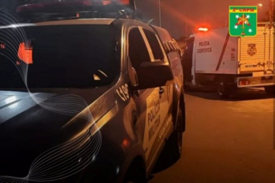 A imagem mostra uma viatura da Polícia Militar e um carro do IML