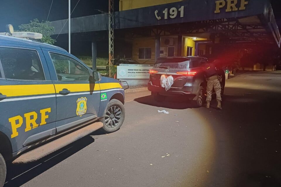 A imagem mostra um carro sendo vistoriado pela PRF