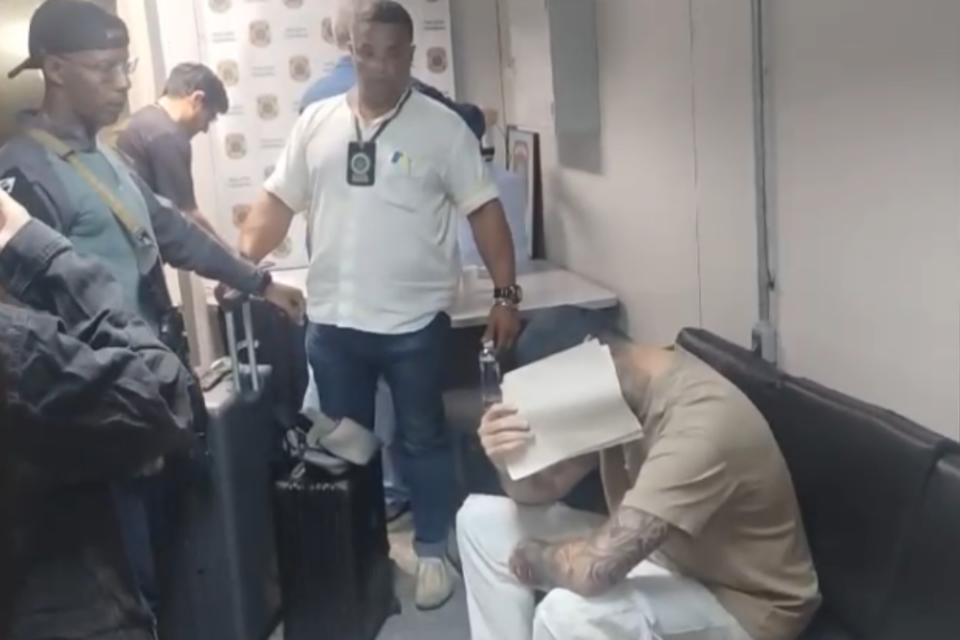 Imagem do suspeito cercado por policiais