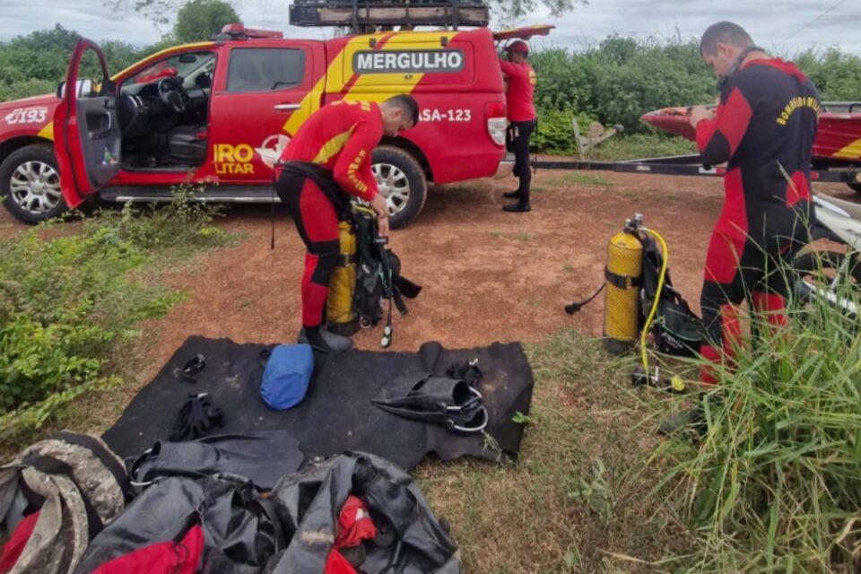 A imagem mostra a equipe de mergulhadores se preparando para fazer as buscas no local