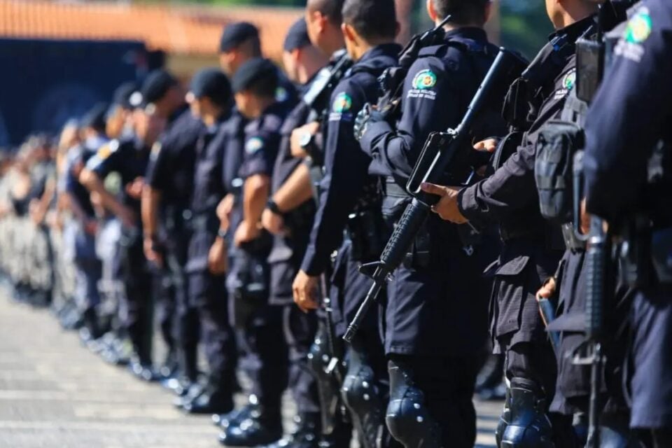 A imagem mostra policiais em fila