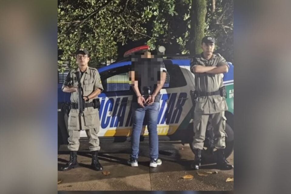 A imagem mostra o homem sendo preso pela Polícia Militar após causar acidente
