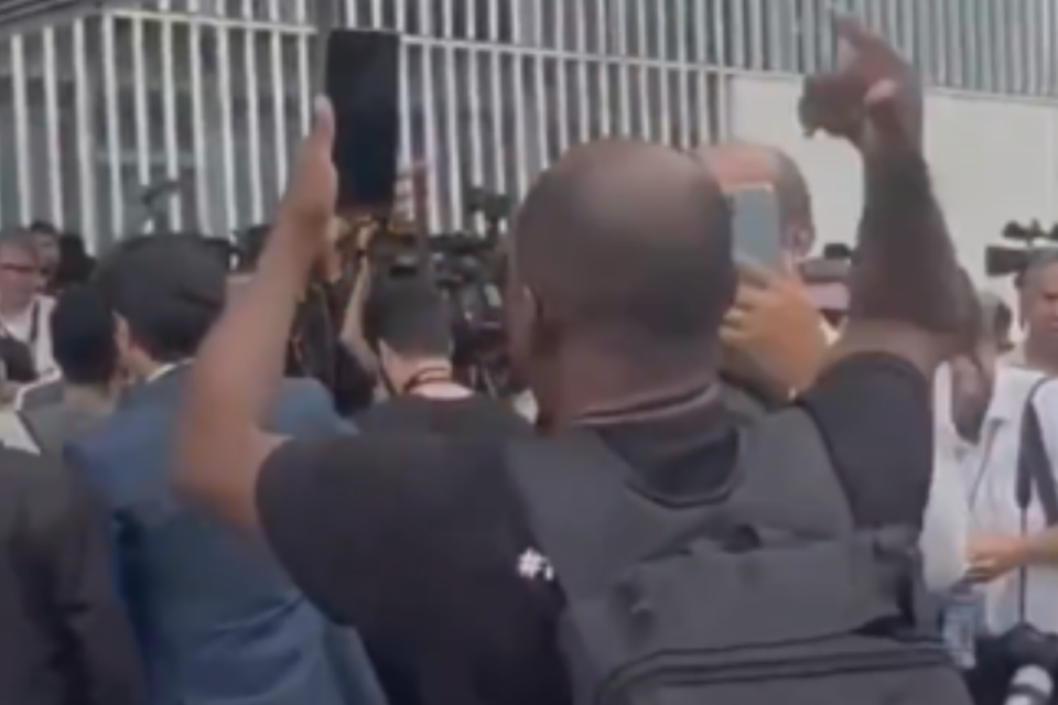 Homem fazendo protesto na entrevista de Bolsonaro (Foto: Reprodução)