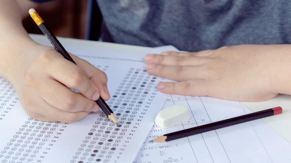 Imagem de uma pessoa preenchendo o gabarito de uma prova